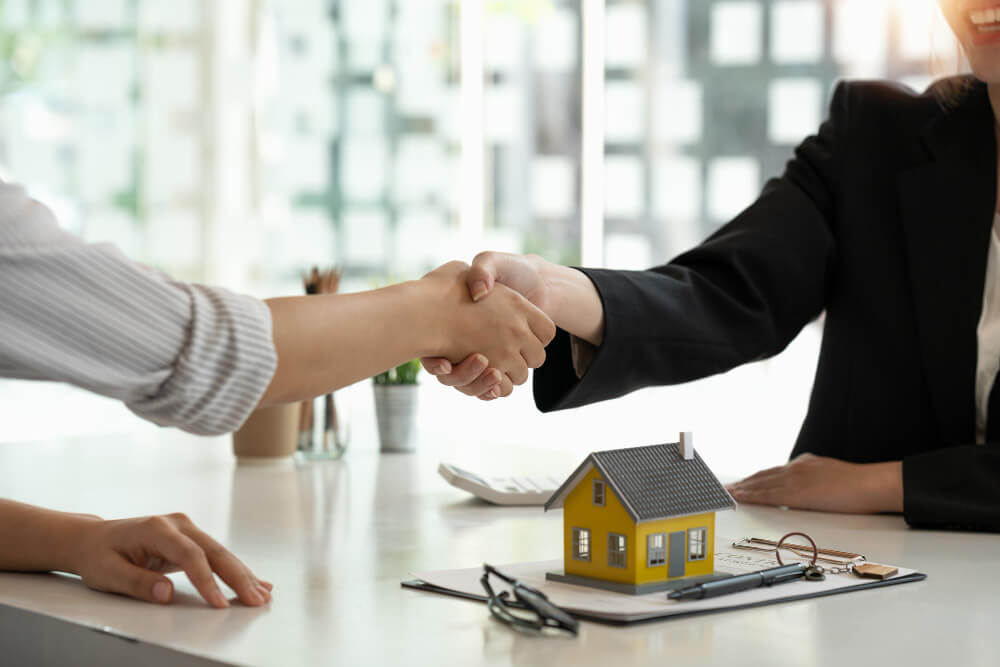 real estate broker customer shaking hands after signing contract real estate home loan insurance concept (1)